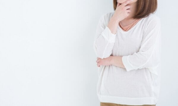 女性が腕組をして考えている写真。